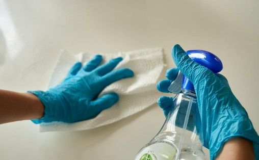 a person cleaning a table with nontoxic cleaner